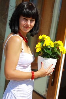 women with the yellow geranium standing near the door