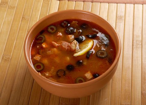 Solyanka on the plate.Solyanka, Russian soup with beef,sausage,chicken and lemon, olives
