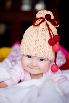 cute happy  baby girl in yellow hat with colourfu bobbles