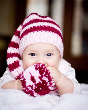 cute baby in a hat with pompom in her hands