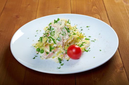 pasta Fettuccine Alfredo with cherry tomato, ham. close-up