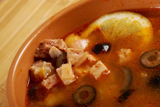 Solyanka on the plate.Solyanka, Russian soup with beef,sausage,chicken and lemon, olives