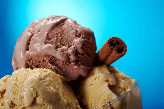 ice cream in with strawberries and chocolate. closeup .on blue background.