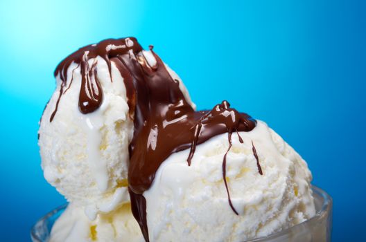 ice cream in with chocolate sauce. closeup .on blue background.