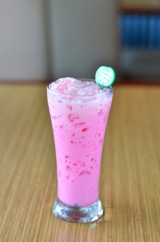 ice pink milk in the glass on table