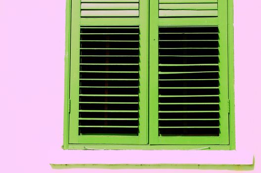 Green shutter windows in a pink wall