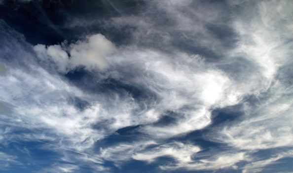 A lot of whispy white clouds in the sky.