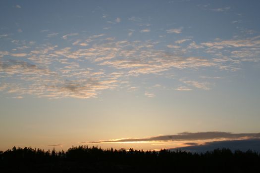 summer sunrise with cloudly sky and forest
