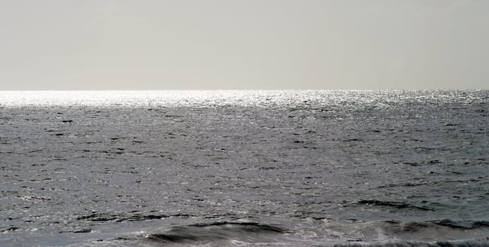 Empty Ocean with some sun reflections in a gray tonal range.