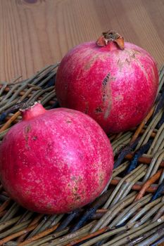 Two Pomegranites on a wicker plate
