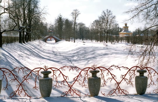 Vases and red branches decoration of the bridge over snowed chanel 