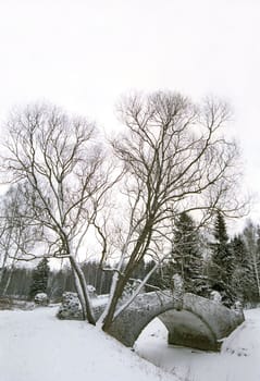 Old bridge over frozen river in winter park