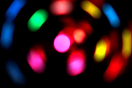 Colorful blurred lights on a dark background.  Used a spin effect.