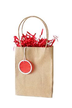 Brown bag with a blan red gift tag hanging from it.  All isolated on a white background.