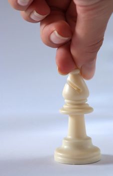 female hand with white chess bishop