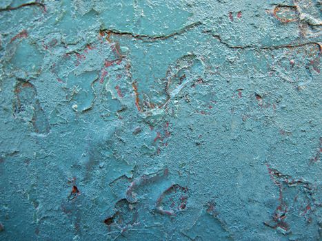 Remnants of vivid red visible beneath a new vivid turquoise paint job