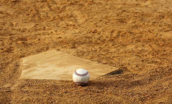 one baseball on home plate at a sports field