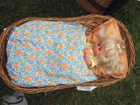 Old style traditional play doll in cradle