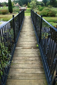 A bridge over a lake in a garden.