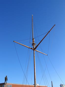 Traditional wooden mast of an old sail boat with clear sky background  