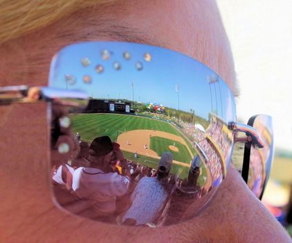 Ball Game and crowd reflection in a woman's sunglasses.