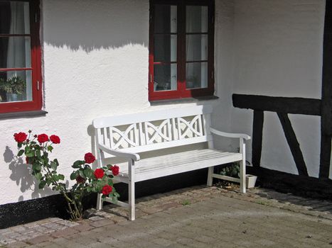 White traditional wooden garden bench in the backyard
