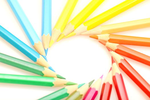 Color pencils in arrange in color wheel colors on white background