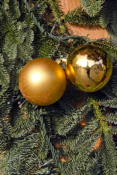 Christmas yellow toys, plastic imitation of fir tree branches. Human silhouette is reflected on toy.