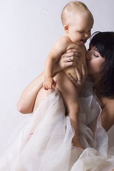 mother kissing little baby on the belly. portrait witch present amazing love