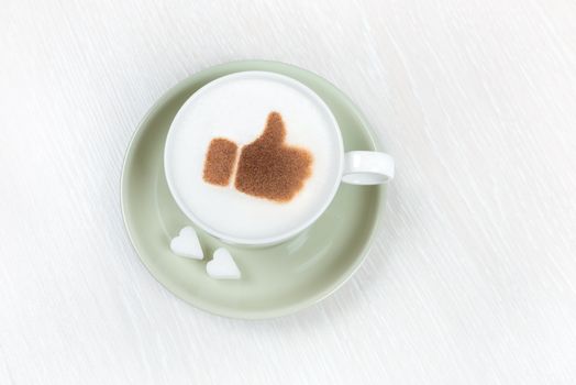 Cup of coffee with chocolate thumbs up and heart shaped sugar