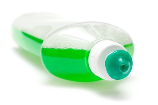 Lying bottle of green bubbling dish liquid isolated on a white background.