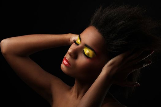 Beautiful black woman with glossy makeup isolated over black background