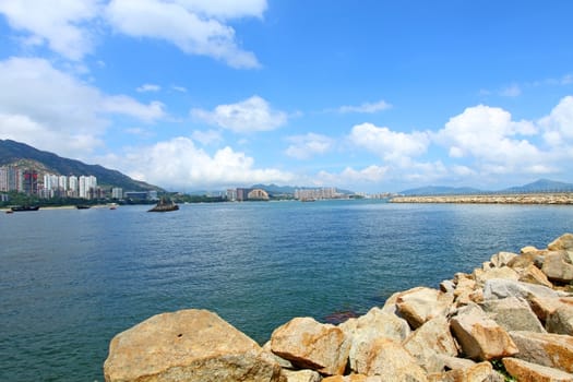 Coastal landscape in Hong Kong at daytime, with many residential buildings.