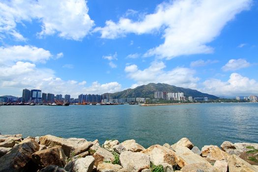 Coastal landscape in Hong Kong at daytime, with many residential buildings. 