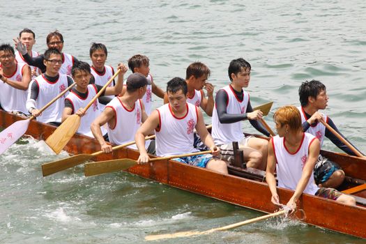 HONG KONG - JUN 6: Athletes fight hard for victory and they won at the dragon boat racing in Tuen Ng Festival 6, June 2011 in Tuen Mun, Hong Kong.