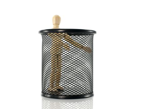 wooden puppet standing in black metal bin