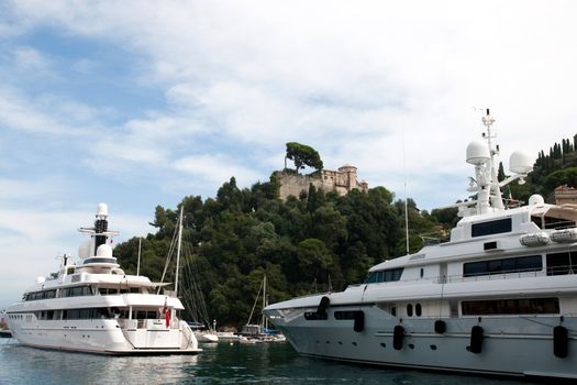 luxury yacht in the Portofino gulf and Castello Brown in background