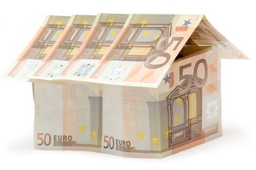 Big house build of fifty euro bills. Isolated on a white background.