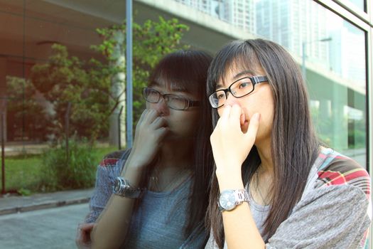 Asian woman with sad face, watching at glasses. 