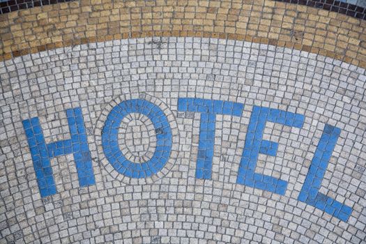 Hotel written in mosaic in front of the entrance - Paris, France.