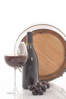 Red wine with grapes and barrel over white background