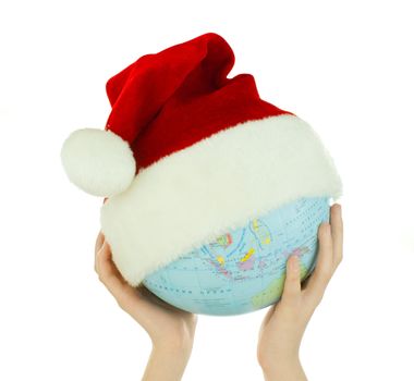 Hands holds globe with Santa's hat over white background