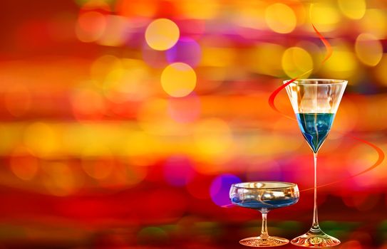 Two blue cocktails with curacao on the background with various colors of illumination of the night city