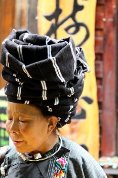 FENGHUANG, CHINA - MAY 12, Miao ethnic minority lady in a market showcasing her culture in Fenghuang, China on 12 May, 2011. She is showing her hat to all the tourists everyday. 