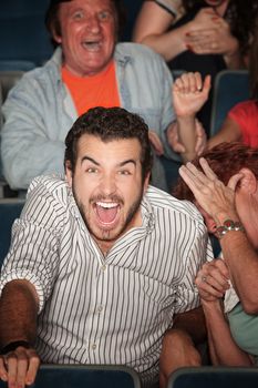 Young Caucasian laughs out loud in theater 