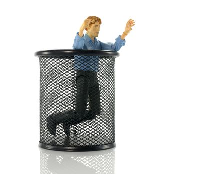 man puppet on his knees in black metal bin