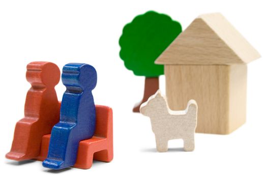 Couple with dog sitting in front of their home. Playthings isolated on a white background.