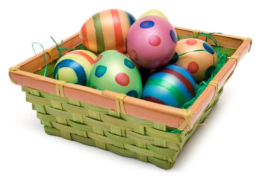 Colorful easter eggs in a wooden basket. Isolated on a white background.