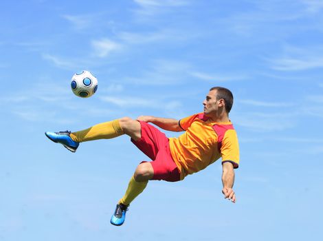 A soccer player kicking the ball in an acrobatic position.