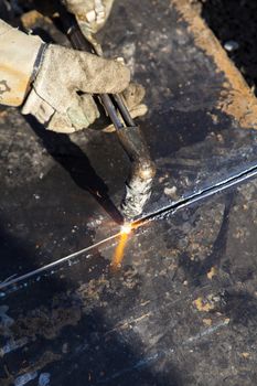 Men at work in rig station welding iron plate